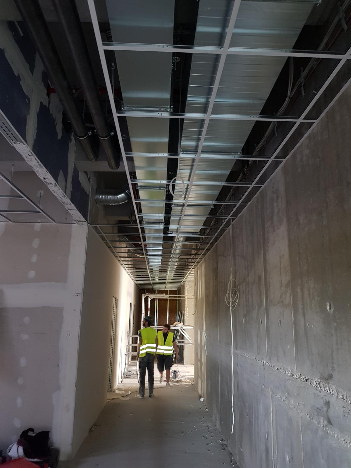 Großprojekt Elektroinstallation Karlsruhe – Stromträger, Deckenkonstruktion und Elektriker in Flur eines Rohbaus